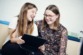 To piger, der ser på en tablet