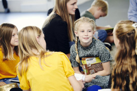 Børnefolk og pige med bog i hånden