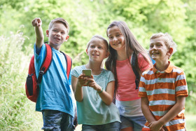Billede af børn i skoven med mobiltelefoner i hånden